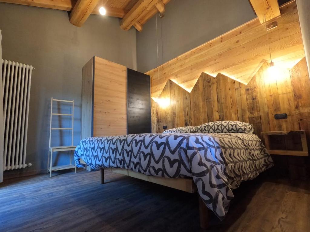 una camera con letto e parete in legno di Appartamenti il bersaio Alloggio 3 a Sambuco