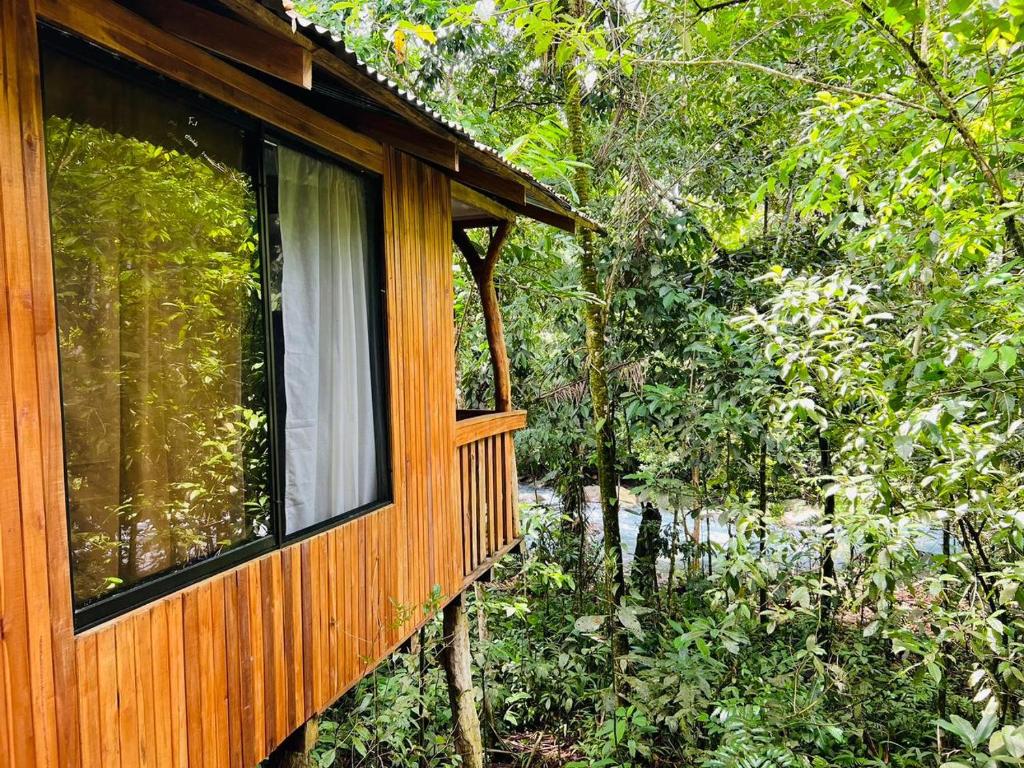 Casa de madera con ventana en el bosque en Villa Celeste Katira, en Rio Celeste