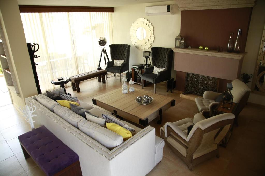 sala de estar con sofá, mesa y sillas en San Pietro Boutique Hotel, en Guadalajara