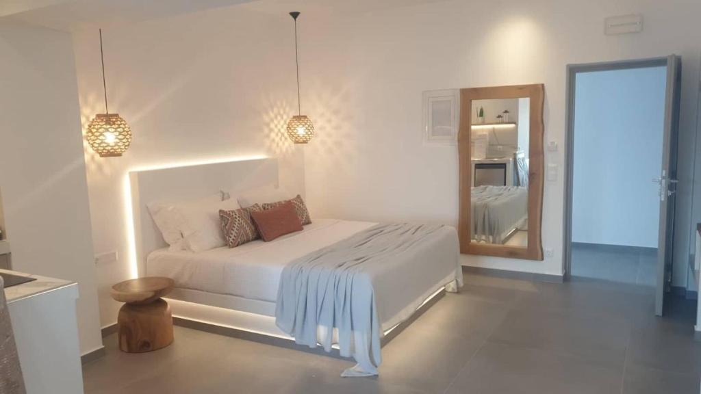 um quarto branco com uma cama e um espelho em Nautica suites - Executive suite with jacuzzi em Antiparos Town