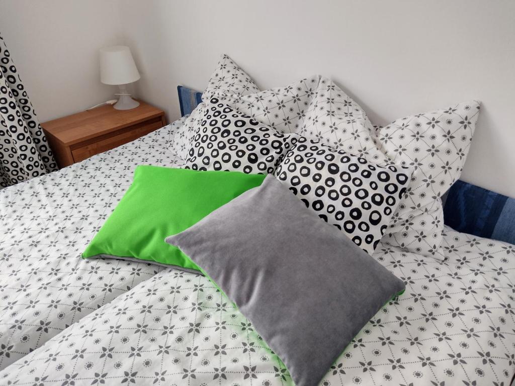 a bed with gray and green pillows on it at Satori in Władysławowo