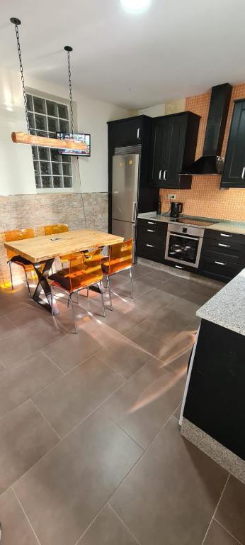a large kitchen with a wooden table and chairs at Casa con encanto in Cariño