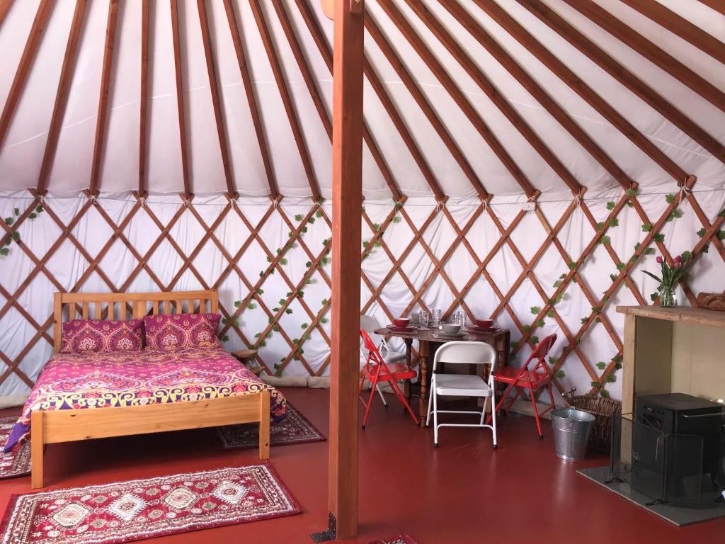 een slaapkamer in een yurt met een bed en een tafel bij The Yurts at Burnt House Farm in Newport