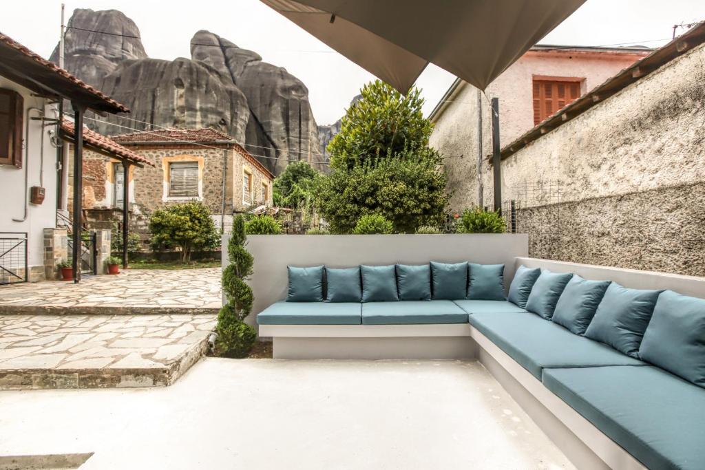 a blue couch sitting in the courtyard of a building at Avli Luxurious House in Kalabaka