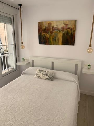 a bedroom with a white bed with a pillow on it at Apartamento MARIANA in Granada