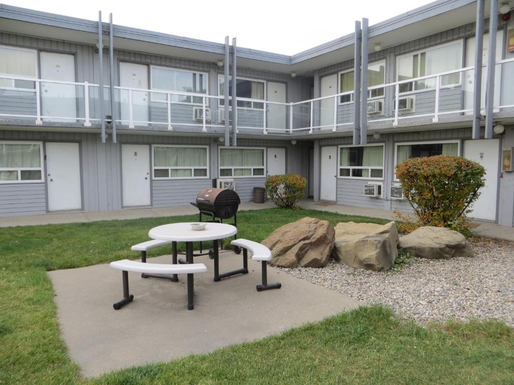 un edificio con dos mesas y una parrilla en un patio en Travellers Inn, en Calgary