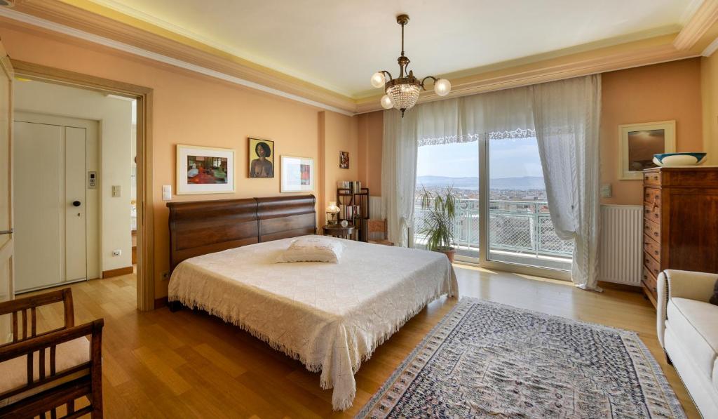 een slaapkamer met een bed en een groot raam bij Living exceptionally in Thessaloniki