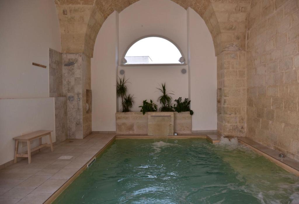 une salle de bains avec une grande piscine d'eau dans l'établissement LeVolte luxury suite&spa, à Sternatia