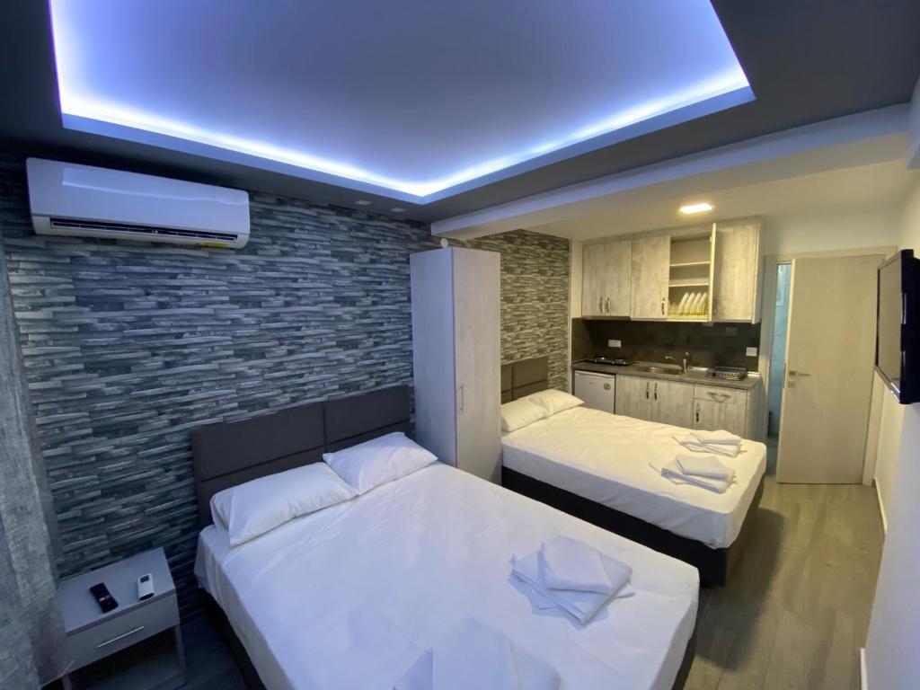- une chambre avec 2 lits et un mur en briques dans l'établissement Vila Savic, à Olympiakí Aktí