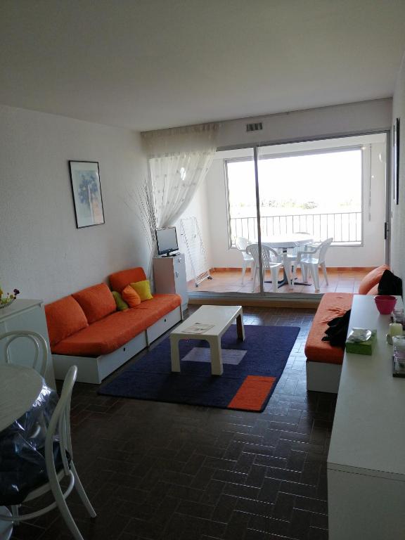 un salon avec un canapé et une table dans l'établissement cap d'agde 54m2 face à la mer, au Cap d'Agde