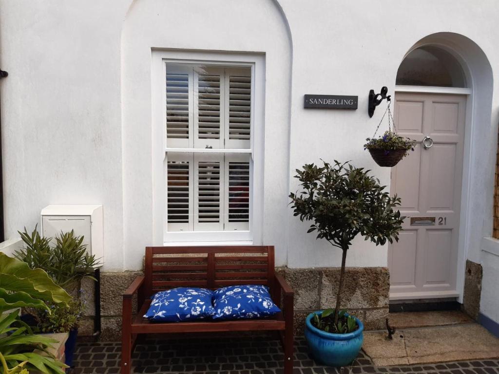 eine Bank vor einem Haus mit einer Tür in der Unterkunft Sanderling - Grade 2 Listed Georgian Townhouse by the sea in Penzance