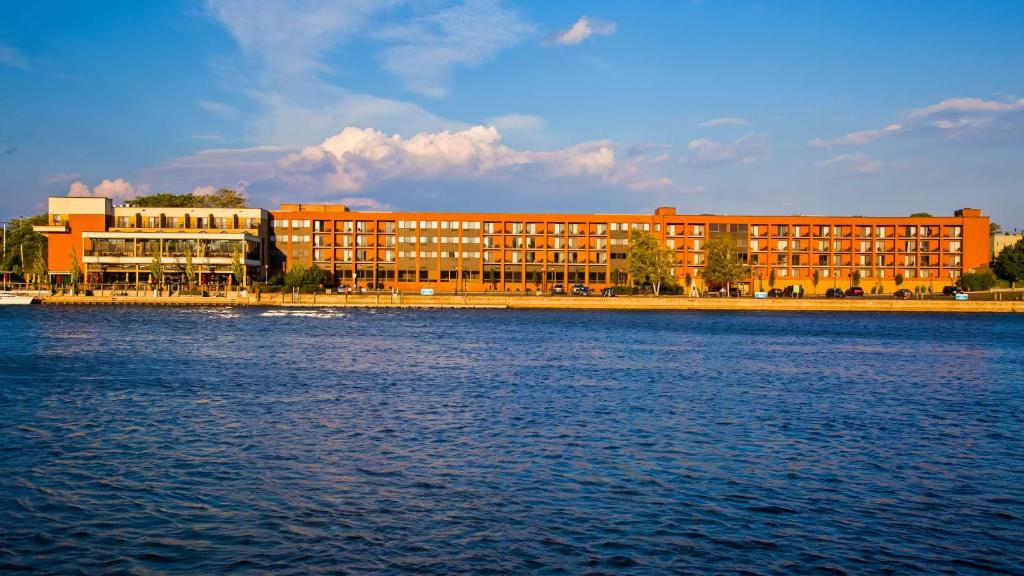 Best Western Plus Oswego Hotel and Conference Center في اوسويغو: مبنى كبير بجانب تجمع كبير للمياه