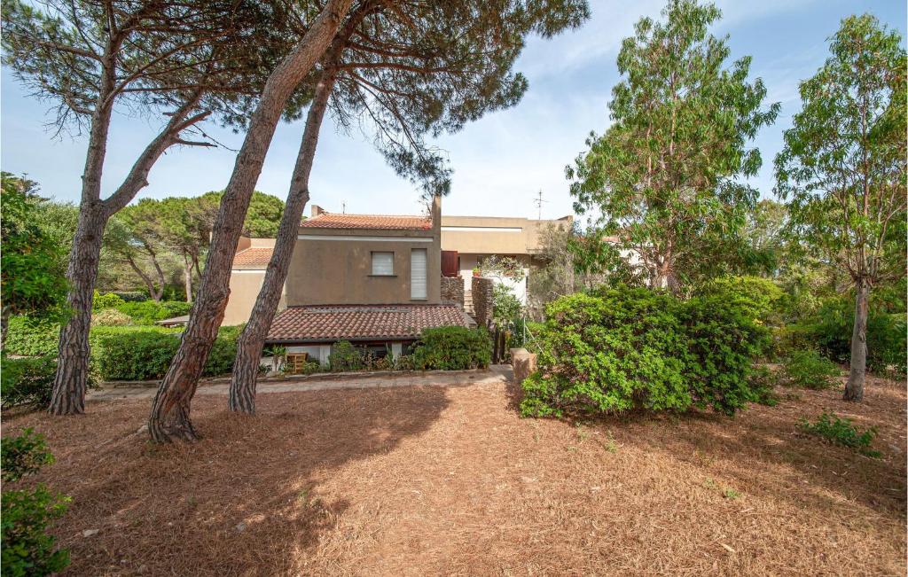 a house with trees in front of a yard at 1 Bedroom Awesome Apartment In Stintino in Stintino