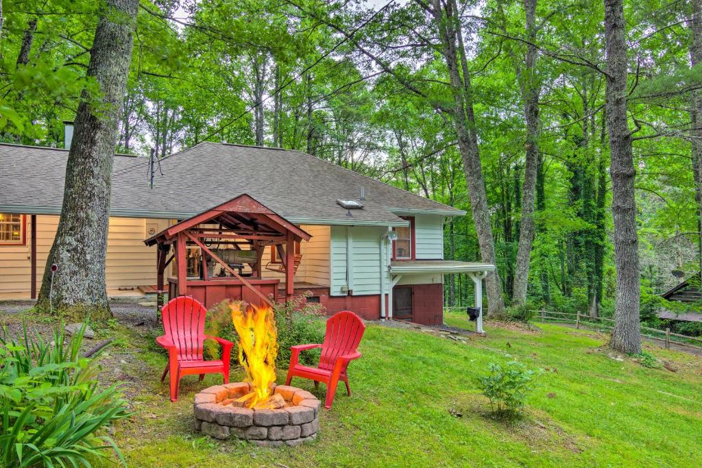 een achtertuin met twee stoelen en een vuurplaats voor een huis bij Rustic Linville Falls Cottage with Fire Pit! in Linville Falls