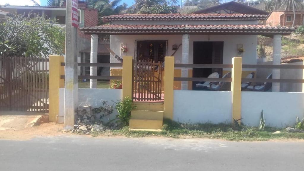 una casa con una puerta y una valla en Uma casa para descansar em um cenário paradisíaco., en Icapuí