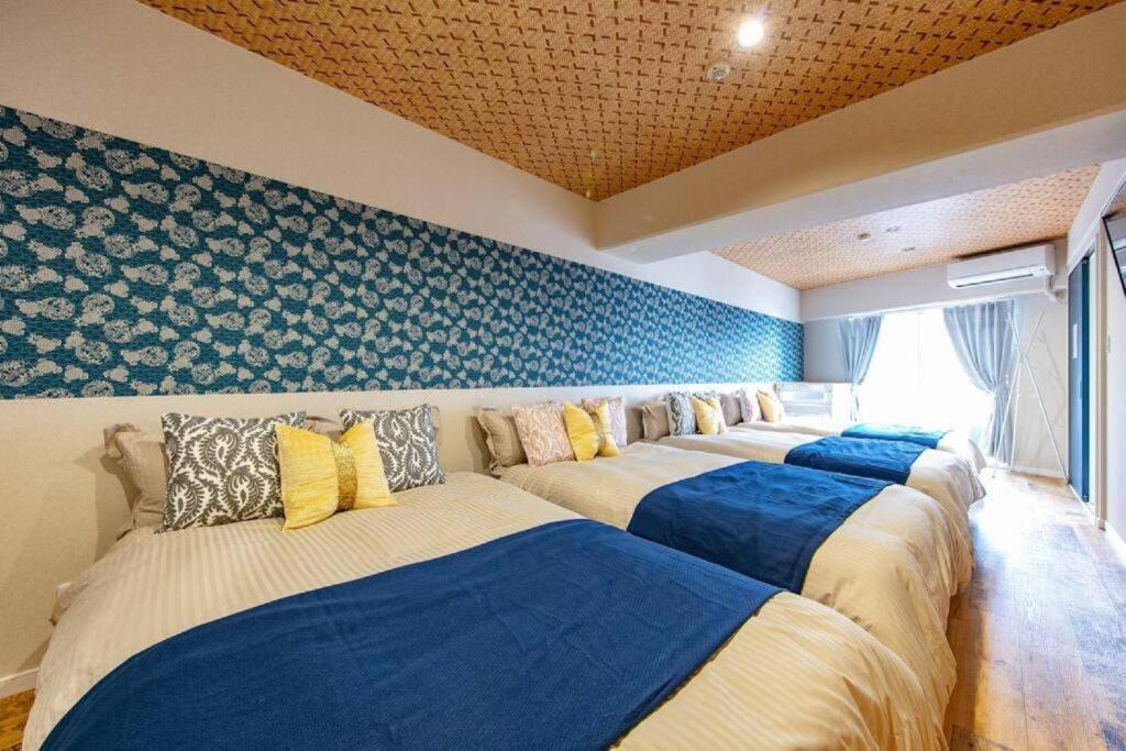 eine Reihe von 4 Betten in einem Zimmer in der Unterkunft Early Arc Osaka in Osaka