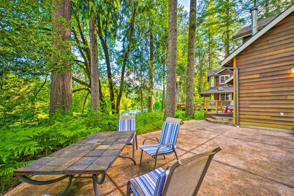 un patio con mesa de madera, sillas y árboles en The River House with Deck, on McKenzie River!, en Springfield