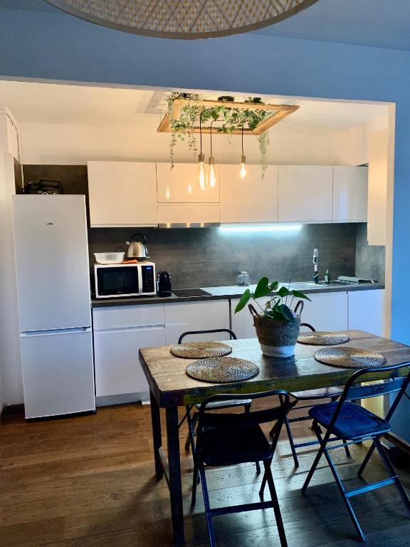 une cuisine avec une table avec des chaises et un réfrigérateur dans l'établissement Le Magilena T2, à Cannes