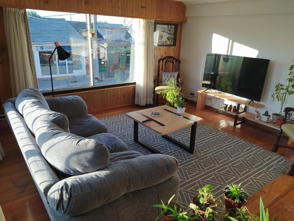 un soggiorno con divano e tavolo di Casa Campo B&B a San Carlos de Bariloche