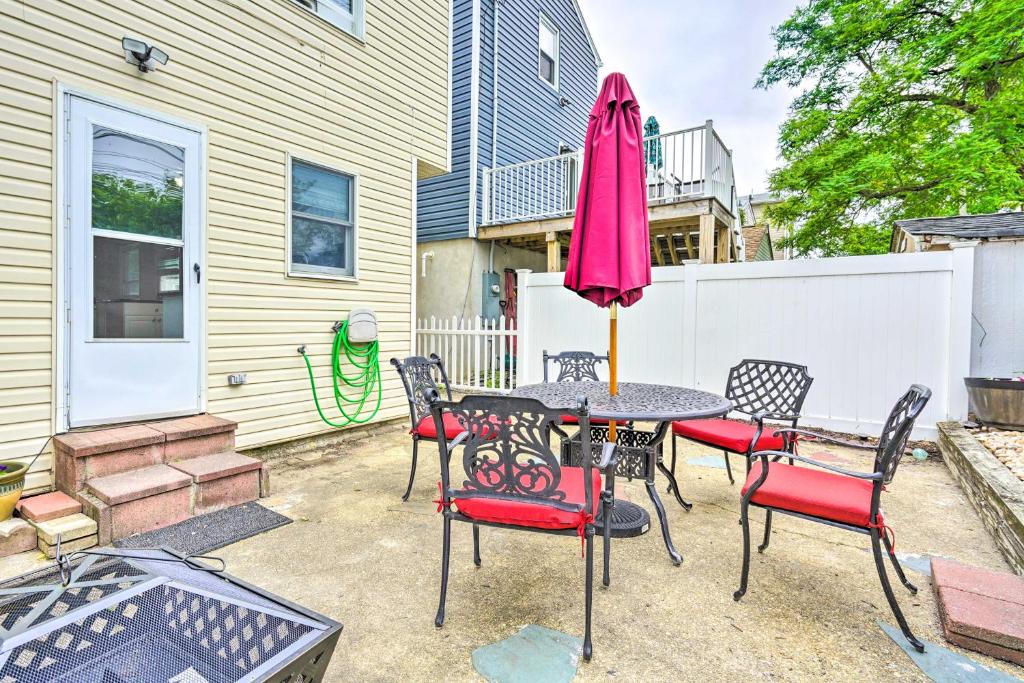 a patio with a table with chairs and an umbrella at Family-Friendly Keansburg Home Walk to Beach! in Keansburg