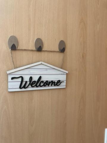 a welcome sign on the side of a wooden door at T0 no centro do Porto in Porto