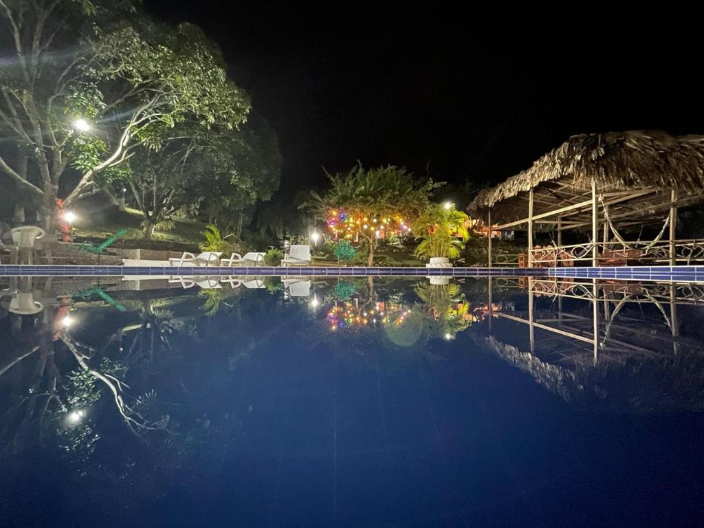 eine nächtliche Aussicht auf einen Pool mit einem Resort in der Unterkunft Entre Bosques Tayrona in Los Naranjos