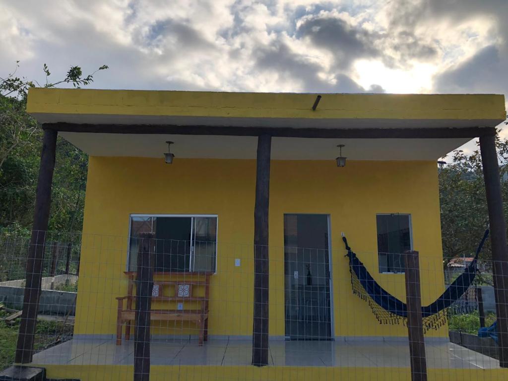 a yellow building with a black fence in front of it at Flat Boa Vista Beach in Paraty