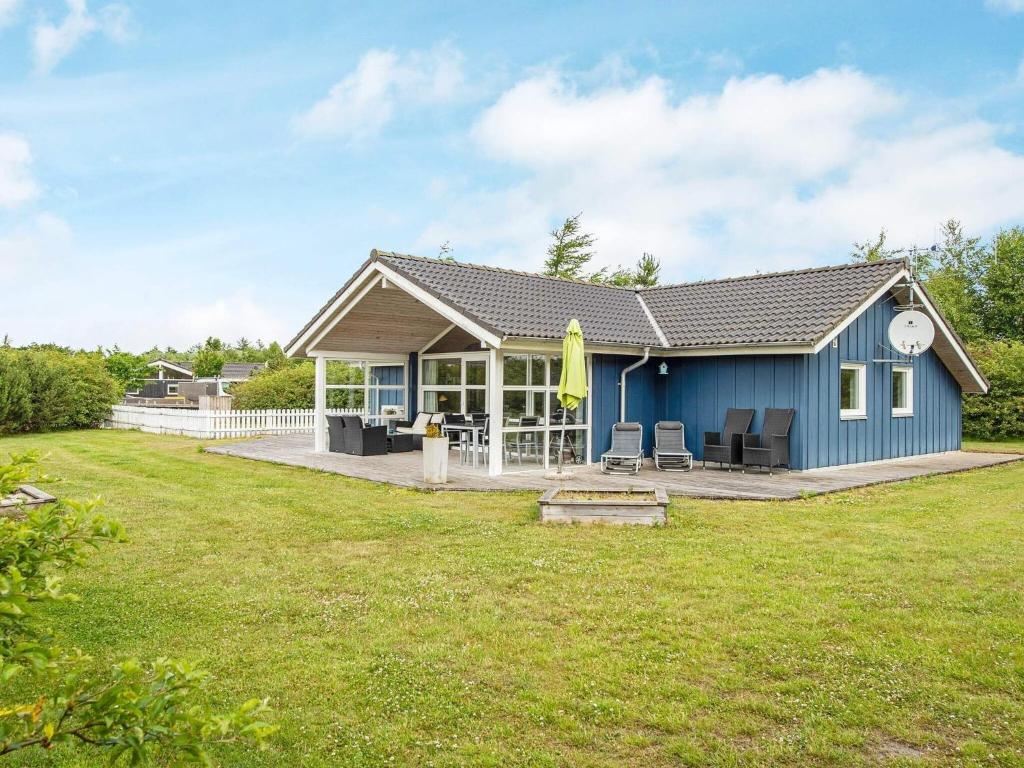 a blue house with a lawn in front of it at Holiday Home Duevænget IV in Hemmet