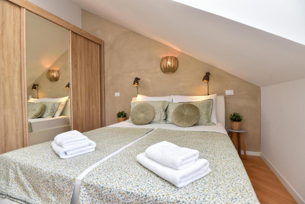 a bedroom with a large bed with towels on it at Apartment Sunny Bay - FREE PARKING in Dubrovnik