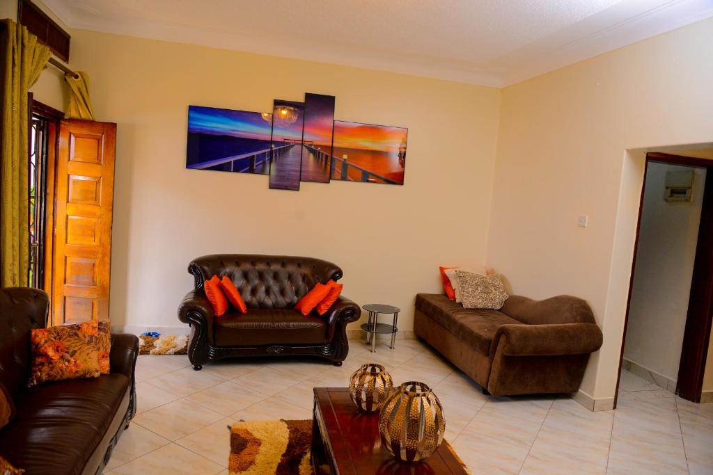 ein Wohnzimmer mit 2 Sofas und einem Sofa in der Unterkunft MODERN LUXURIOUS 2BEDS HOUSE IN KAMPALA CITY CTR in Kampala