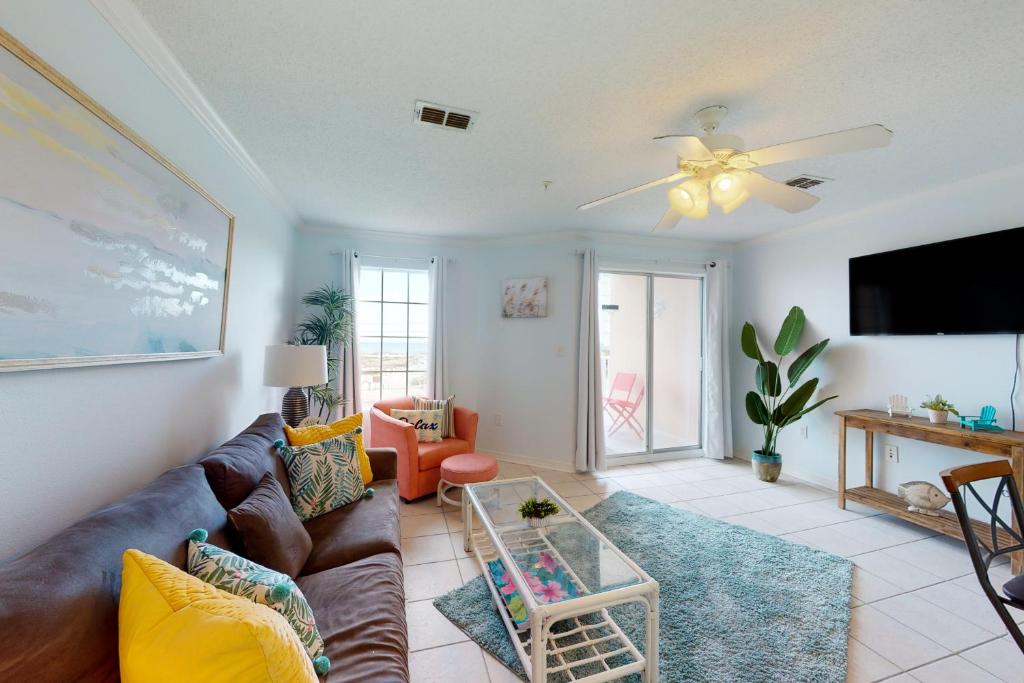 a living room with a couch and a ceiling fan at Grand Beach Resort 303 in Gulf Shores