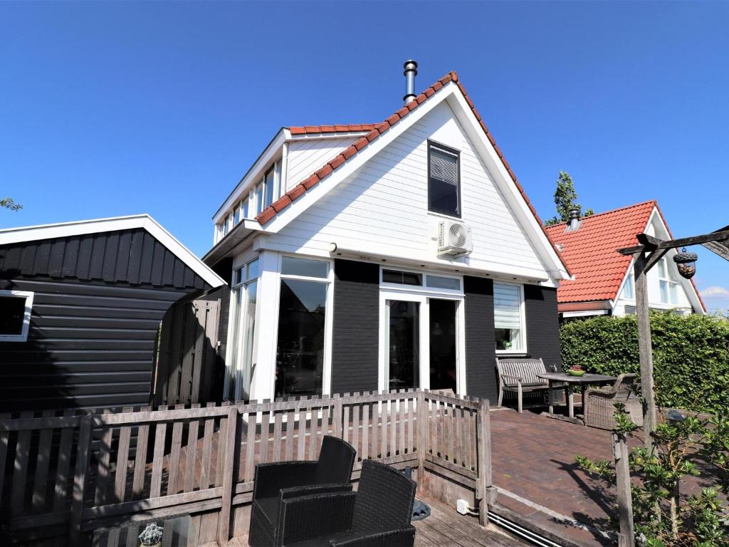 赫勞的住宿－Detached vacation home in Friesland with waterfront views，白色的房子,设有门廊和甲板