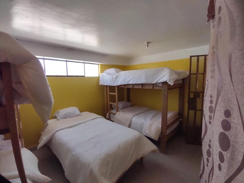 a bedroom with two bunk beds and a window at BACKPAKERS MIRADOR in Huaraz