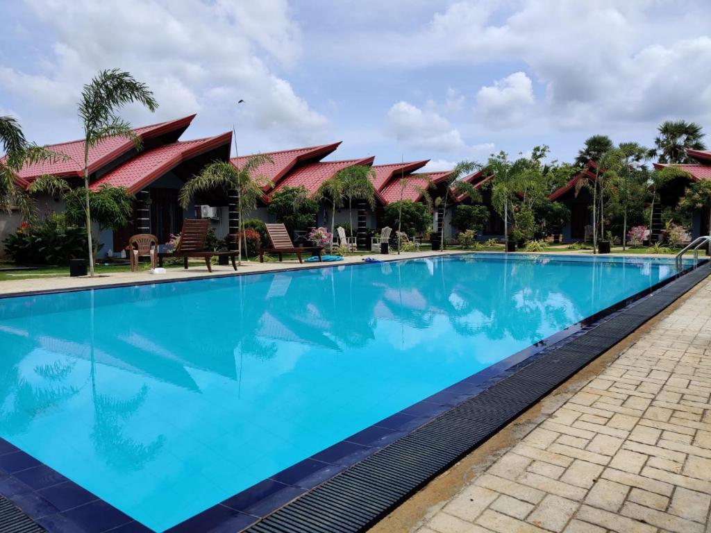 a large blue swimming pool in front of a resort at Anukama Resort in Nilaveli