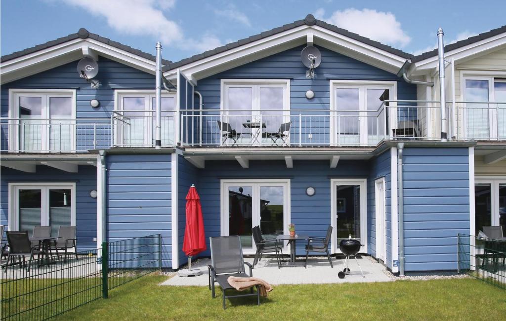 ダゲビュルにあるBeautiful Home In Dagebll With 3 Bedrooms, Sauna And Wifiの青い家(椅子とテーブル付)