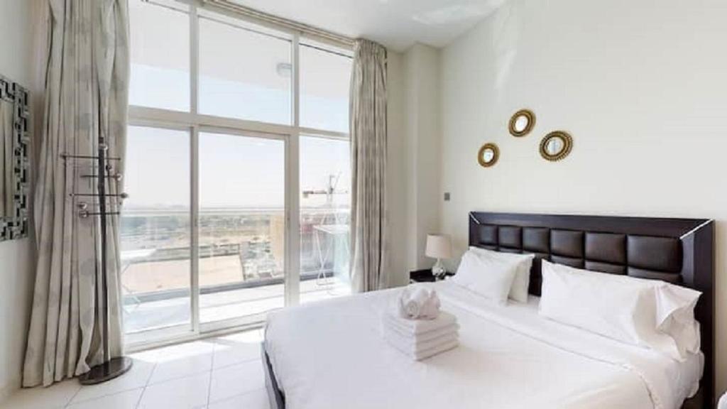 a bedroom with a large bed and a large window at Beautiful Studio Apartment Near New Dubai Mall I Balcony I Parking I Wifi I Furnished rooms in Dubai