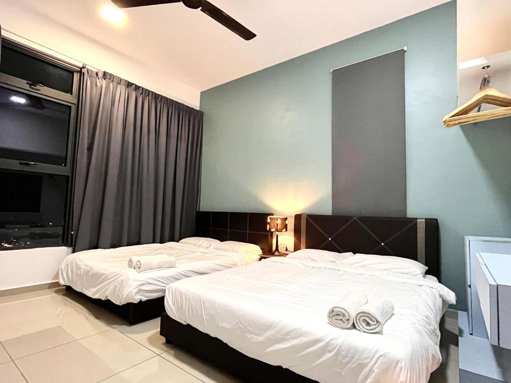une chambre avec deux lits avec des serviettes dessus dans l'établissement Summer House-Atlantis Residence, à Malacca