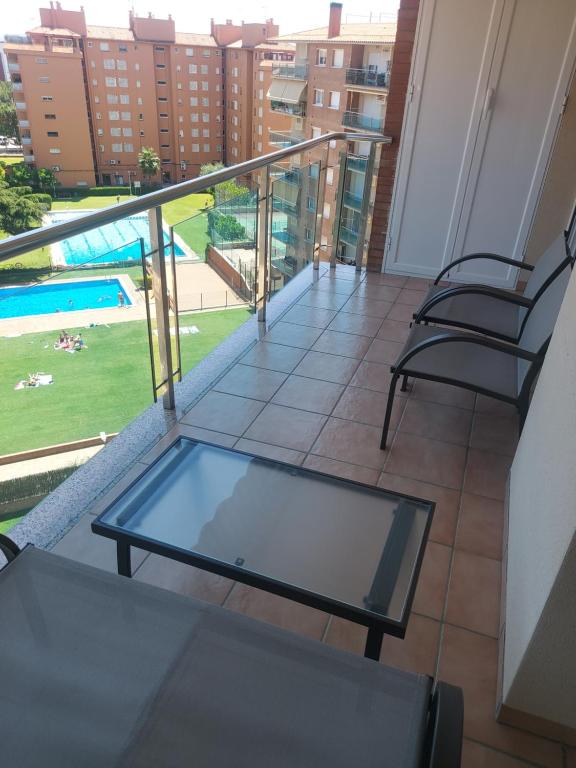 a balcony with two chairs and a glass table at Brisa Beach in Santa Susanna