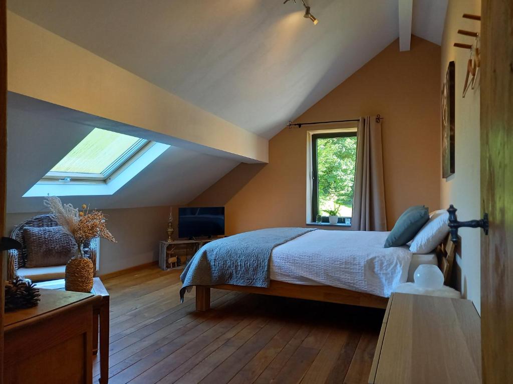 a bedroom with a bed and a skylight at Le Clos du Cerf - Silence & nature in Stoumont