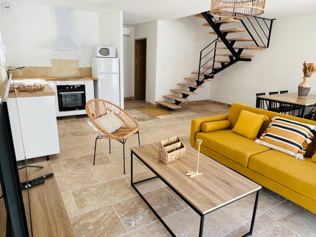 a living room with a yellow couch and a table at Résidence L’Oiseau des Sables in Saintes-Maries-de-la-Mer