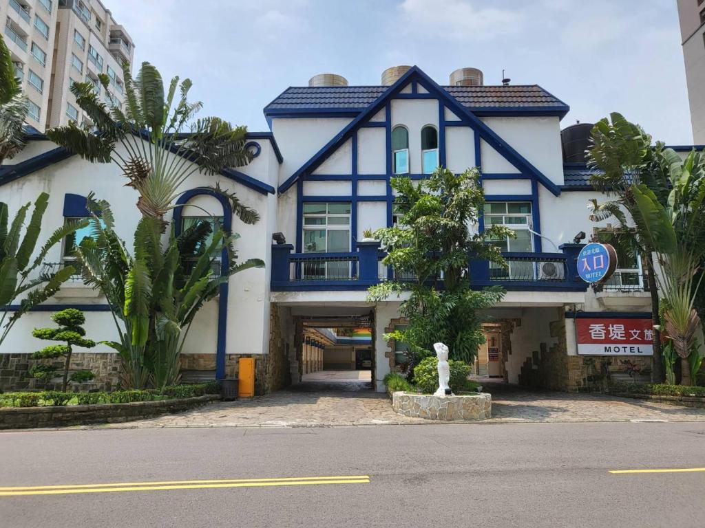 een groot blauw-wit gebouw met een veranda bij Chateau Motel & Spa - Nanzi in Liugui
