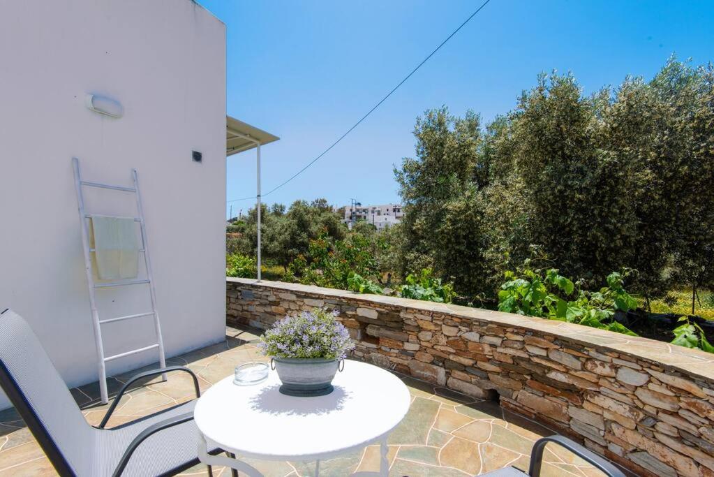 a patio with a table and chairs and a stone wall at Studios Margarita in Artemonas