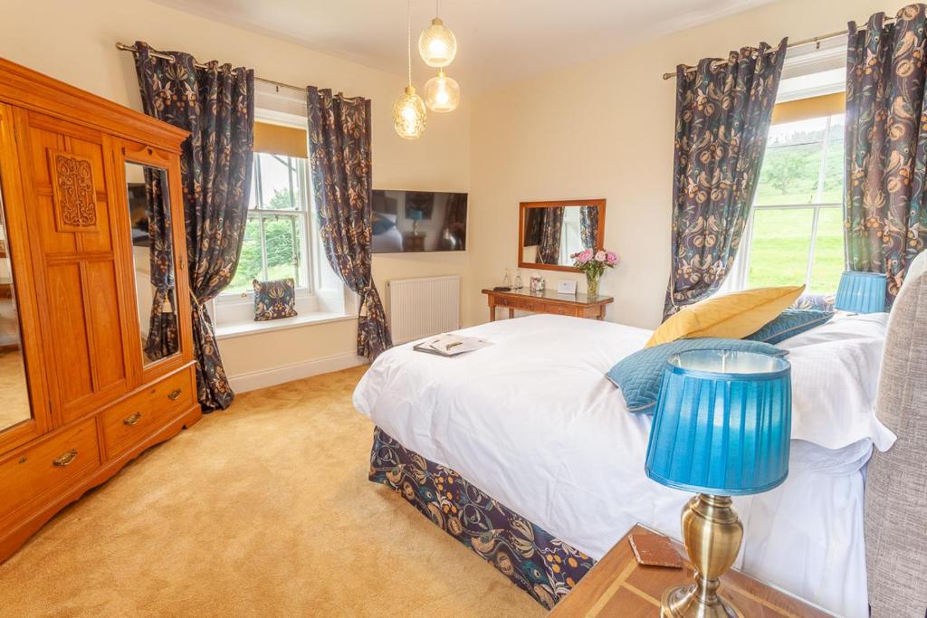 a bedroom with a bed and two windows at Country Getaway - Tosson Tower Farm in Rothbury