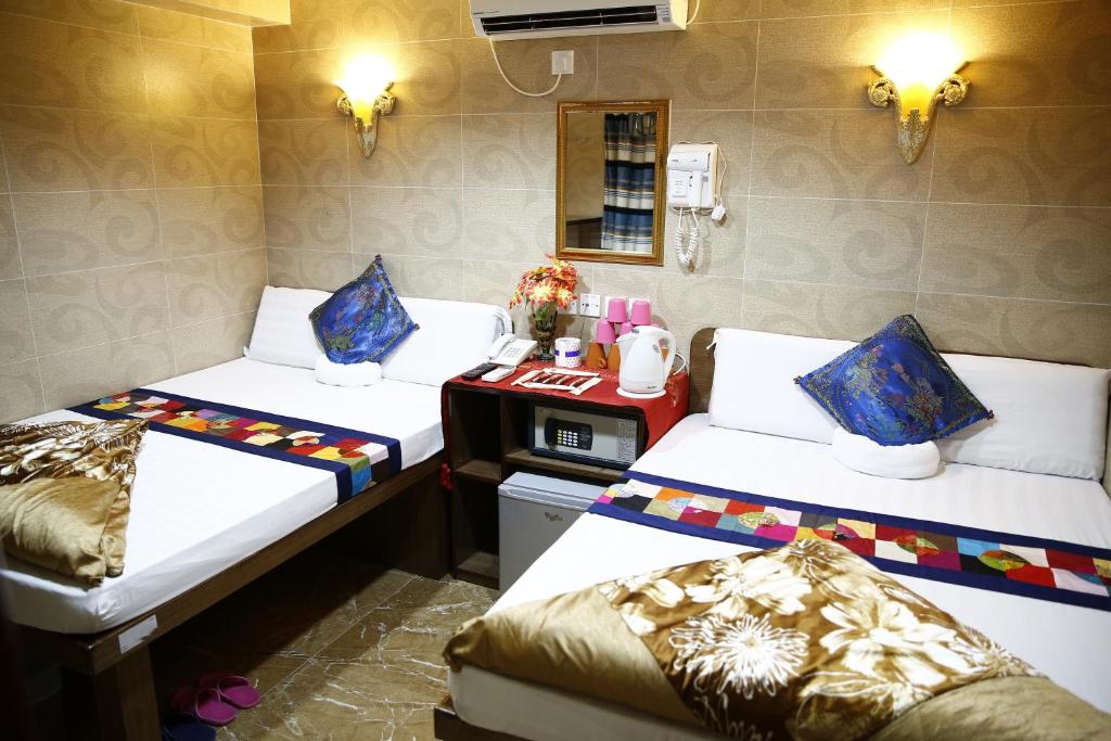 Habitación con 2 camas y escritorio. en Sandhu Guest House en Hong Kong