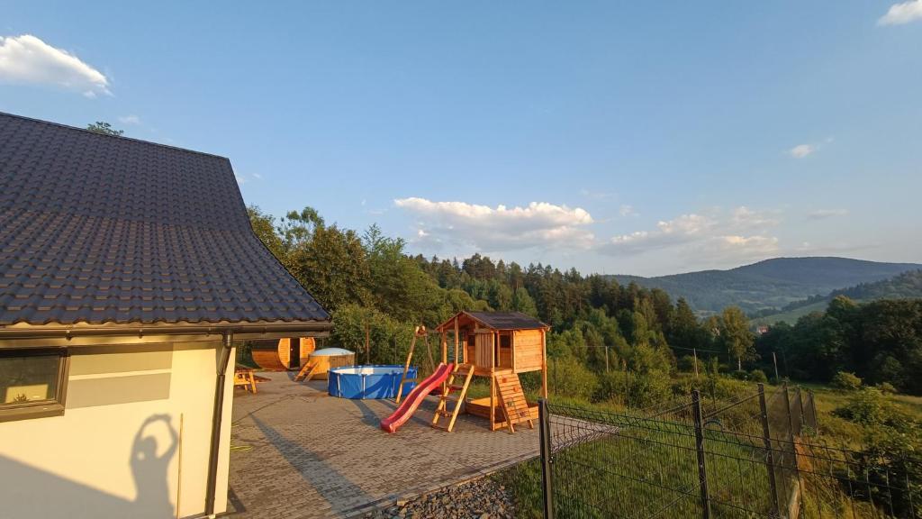 una casa con parque infantil y una casa en Sarnie wzgórze Sucha Beskidzka sauna jacuzzi, en Kuków