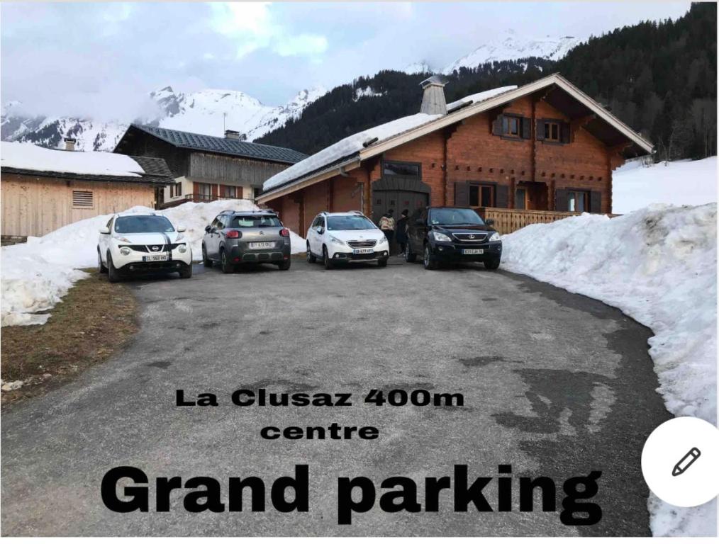 un groupe de voitures garées devant une maison dans l'établissement La Clusaz Ski aux pieds, à La Clusaz