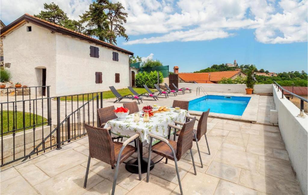 een patio met een tafel en stoelen en een zwembad bij Casa Storia & Casa Antica in Veprinac