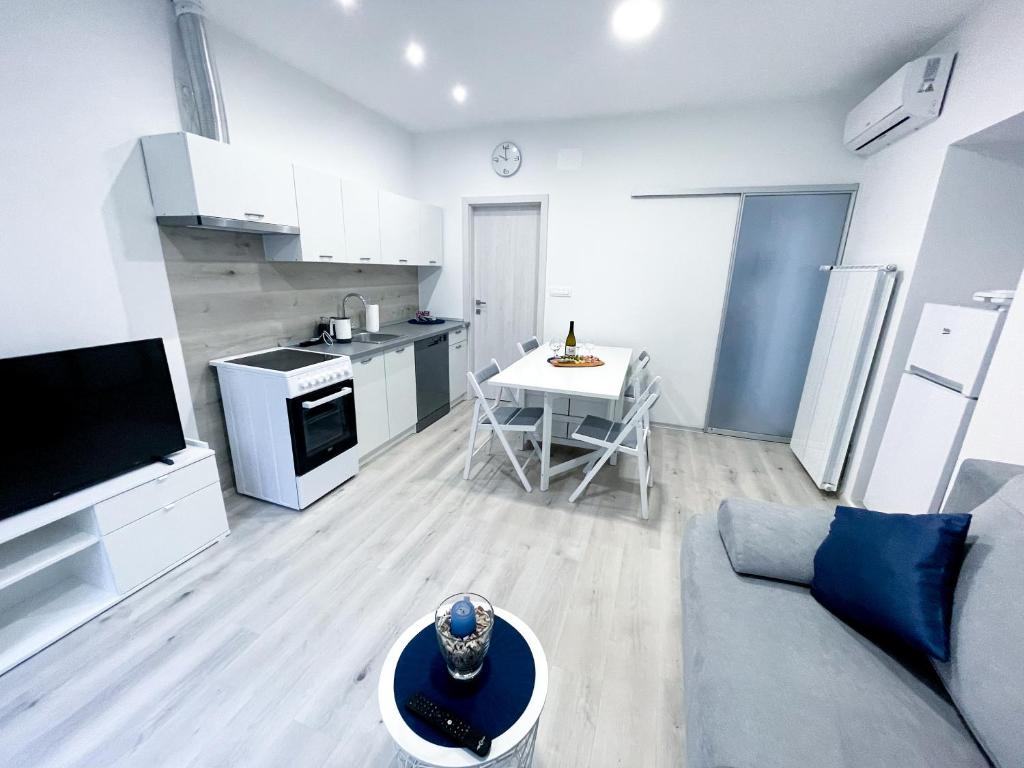uma cozinha e sala de estar com um sofá e uma mesa em APARTMA GALEB em Piran
