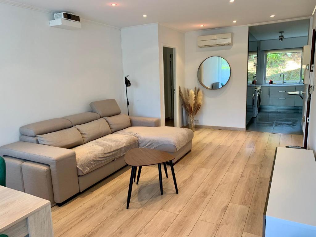 a living room with a couch and a table at Appartement en résidence avec piscine in Nice