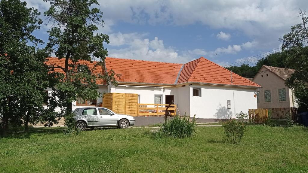 una pequeña casa blanca con techo naranja en Lovas Vendégház, en Óbánya